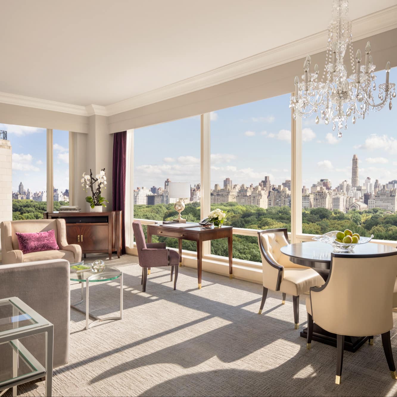Posh living area of luxury apartment near Rockefeller Center with floor-to-ceiling windows and sweeping view of skyline